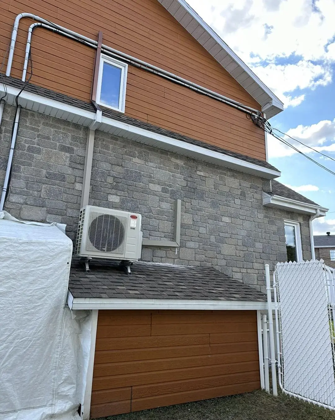 Thermopompe murale installée par Groupe RENOX sur le mur extérieur d'une maison